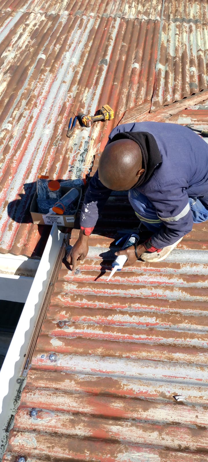 Linobunjo worker sealing a corrugated roof