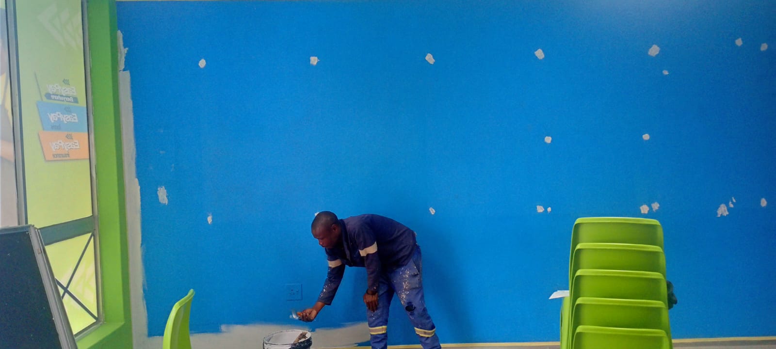 Worker painting a commercial interior wall